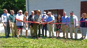 Don Harrison, President of the Friends, is second from the right at the ribbon-cutting. Bert Swain, who grew up in the house, is standing on one side of Don.